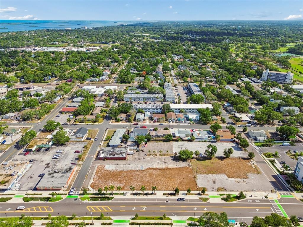 An aerial view shows a large vacant lot situated in a suburban neighborhood near water — 1214-1242 CLEVELAND STREET, CLEARWATER, FL