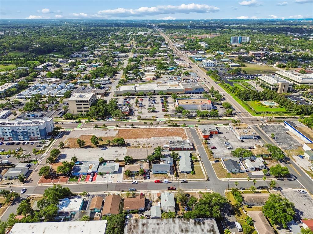 An aerial view shows a city landscape with a large vacant lot in the foreground — 1214-1242 CLEVELAND STREET, CLEARWATER, FL