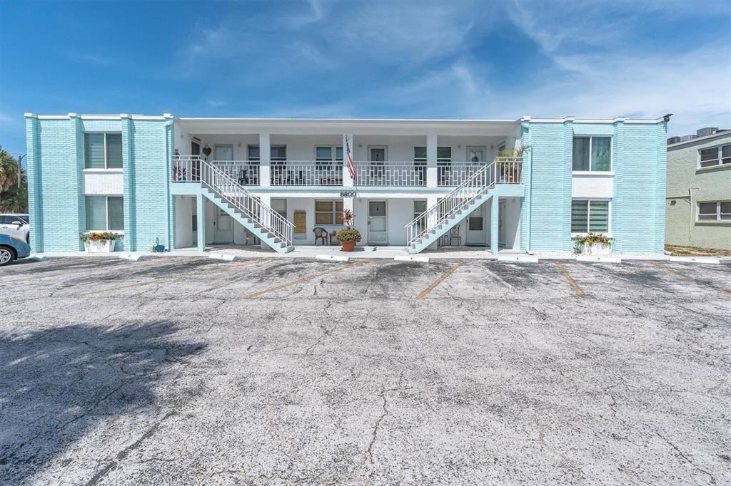 A two-story apartment building with light blue brick siding and an exterior staircase — 8800 BLIND PASS ROAD UNIT 4, ST PETE BEACH, FL