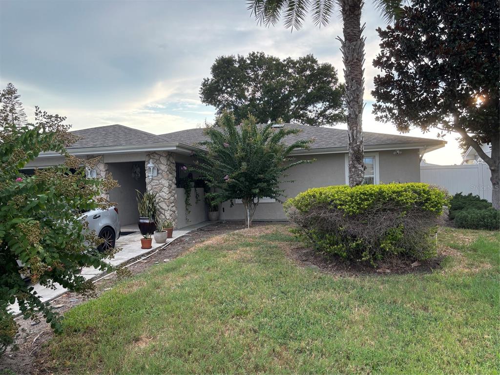 A single-story house with a stone-accented entryway, a paved driveway, and a landscaped front yard — 5450 GAMBIER COURT, ORLANDO, FL