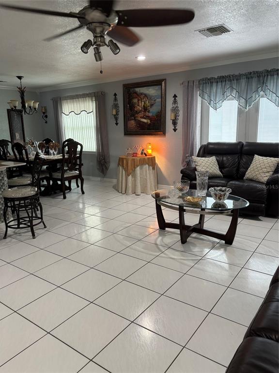 A living and dining area features white tile floors, a ceiling fan, and black furniture — 5450 GAMBIER COURT, ORLANDO, FL
