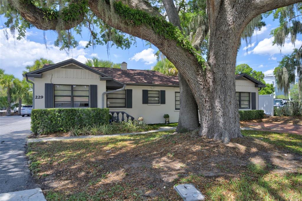 A single-story house with a large oak tree in the front yard — 229 PASADENA PLACE, ORLANDO, FL