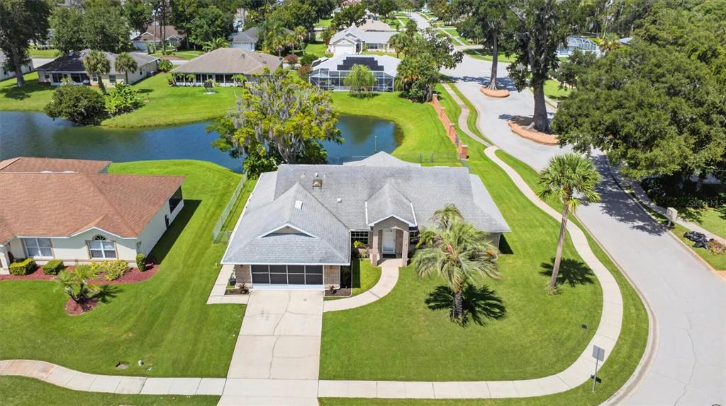 An aerial view shows a single-story house with a gray roof, driveway, and lawn — 31 OLD SUNBEAM DRIVE, SOUTH DAYTONA, FL