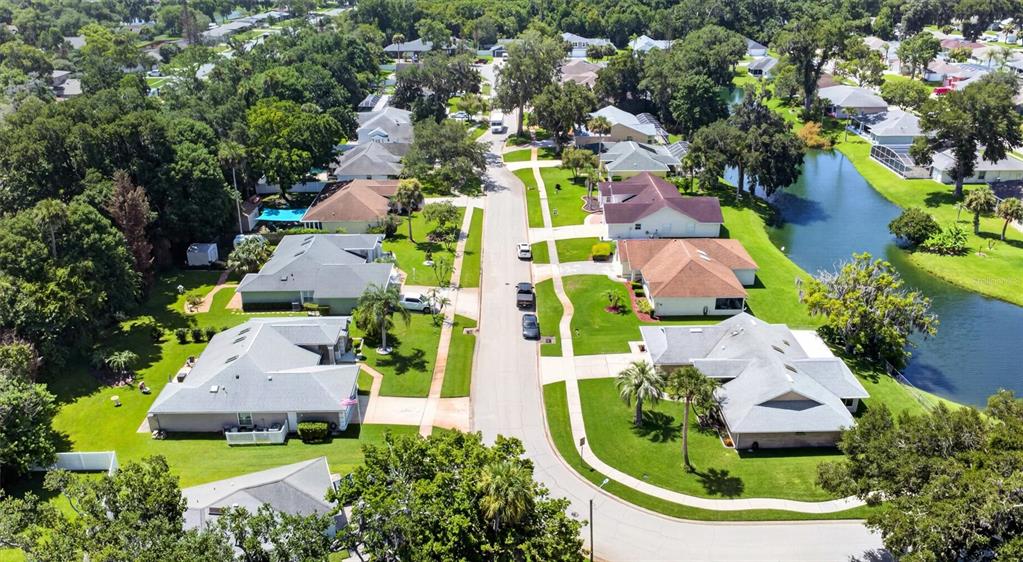 An aerial view shows a suburban street lined with single-family homes and a small lake — 31 OLD SUNBEAM DRIVE, SOUTH DAYTONA, FL