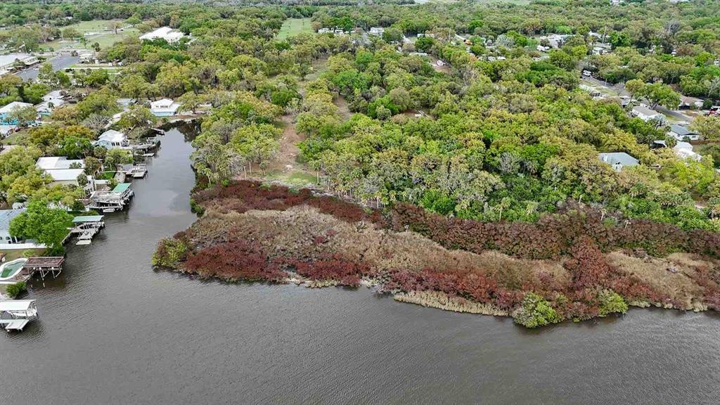 An aerial view shows a waterfront property with a wooded lot and a boat dock — 7013 & 7015 RIVERVIEW DRIVE, RIVERVIEW, FL