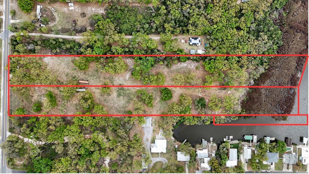 An aerial view shows a rectangular plot of land outlined in red near a waterway — 7013 & 7015 RIVERVIEW DRIVE, RIVERVIEW, FL