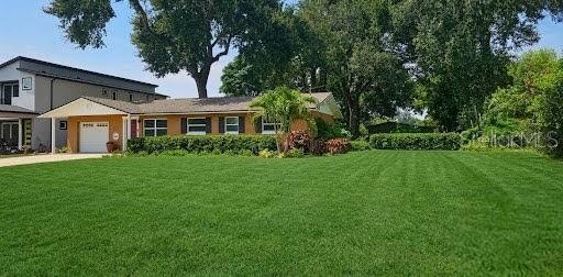 A single-story house with a tan exterior, a garage, and a large front lawn — 1903 SIMONTON AVENUE, ORLANDO, FL
