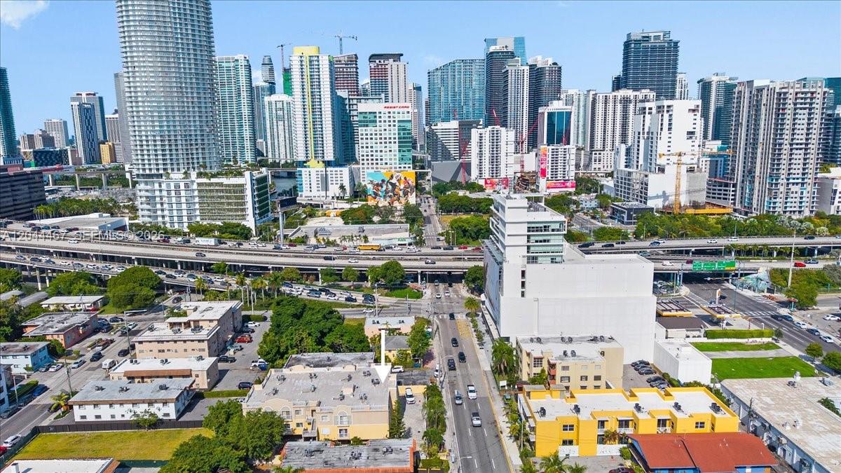 An aerial view of a multi-story apartment building in a dense urban city setting — 437 SW 7th St # 201, Miami FL 33130, MIAMI, FL
