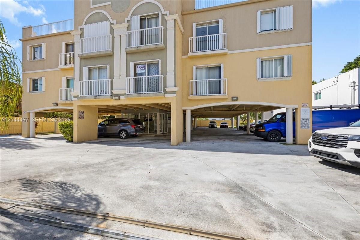 A three-story apartment building with a covered ground-level parking area and a concrete driveway — 437 SW 7th St # 201, Miami FL 33130, MIAMI, FL