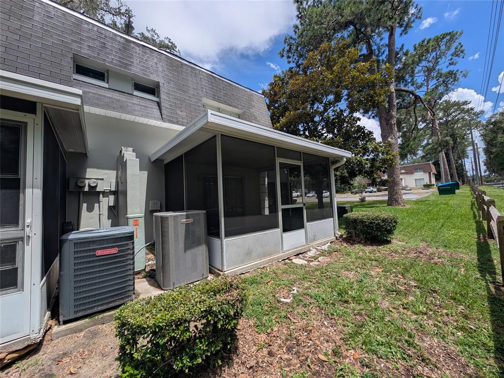 The exterior of a multi-story home features two HVAC units and a screened-in porch — 2524 SE 15TH AVENUE UNIT B, OCALA, FL