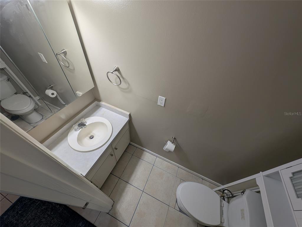 A bathroom features a vanity with a sink, a toilet, and tiled flooring — 2524 SE 15TH AVENUE UNIT B, OCALA, FL