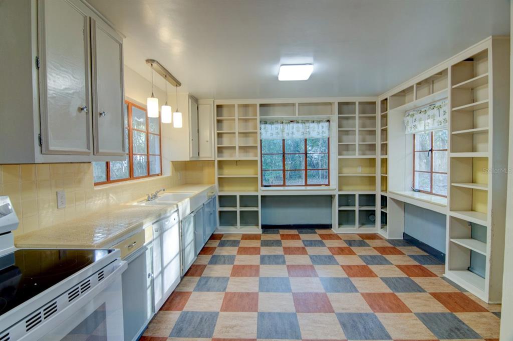 A kitchen with light blue cabinets, yellow tiled countertops, and a checkered floor — 2049 NW 9TH AVENUE, GAINESVILLE, FL
