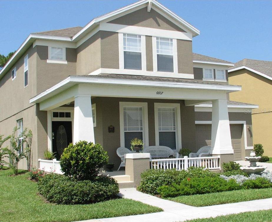 A two-story house with a front porch, a two-car garage, and a concrete driveway — 6607 EARTHGOLD DRIVE, WINDERMERE, FL
