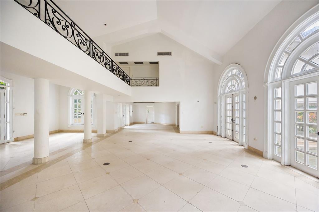 A spacious, white-walled living area features a vaulted ceiling, tiled floors, and an ornate balcony — Urb. San Patricio RIVERA FERRER ST. UNIT 30, GUAYNABO, PR