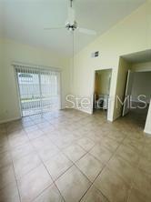 An empty room with light-colored tile flooring, a ceiling fan, and a sliding glass door — 2206 CYPRESS KNEE LOOP, KISSIMMEE, FL