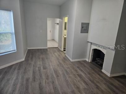 A room with gray wood-look flooring, light gray walls, a fireplace, and a doorway — 306 TURNER STREET UNIT 1, CLEARWATER, FL