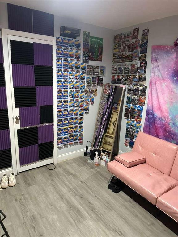 A room features a pink futon, a wall of Hot Wheels cars, and acoustic foam panels — 1524 MANOR DRIVE, KISSIMMEE, FL