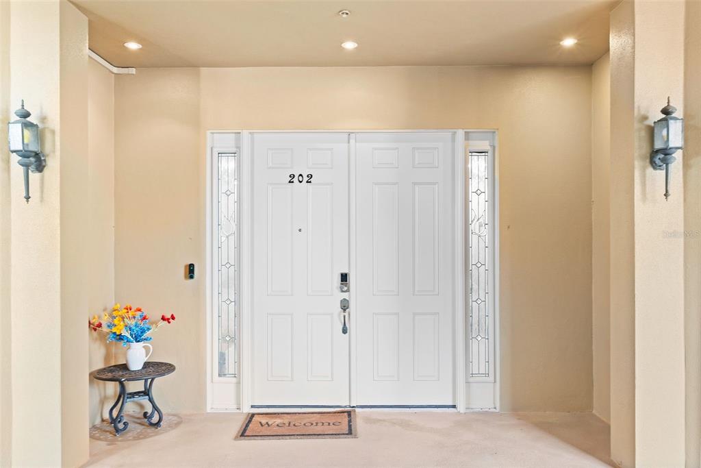 A front entryway features double white doors with the number 202 and a welcome mat — 6100 JESSIE HARBOR DRIVE UNIT 202, OSPREY, FL