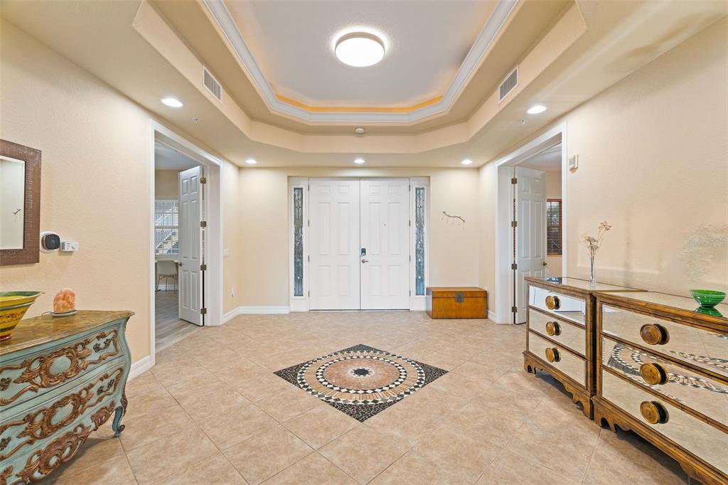 A tiled entryway features a tray ceiling, double front doors, and mirrored furniture — 6100 JESSIE HARBOR DRIVE UNIT 202, OSPREY, FL