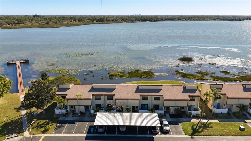 An aerial view shows a multi-unit townhouse complex with a carport, dock, and lakefront — 9209 SEMINOLE BOULEVARD UNIT 32, SEMINOLE, FL