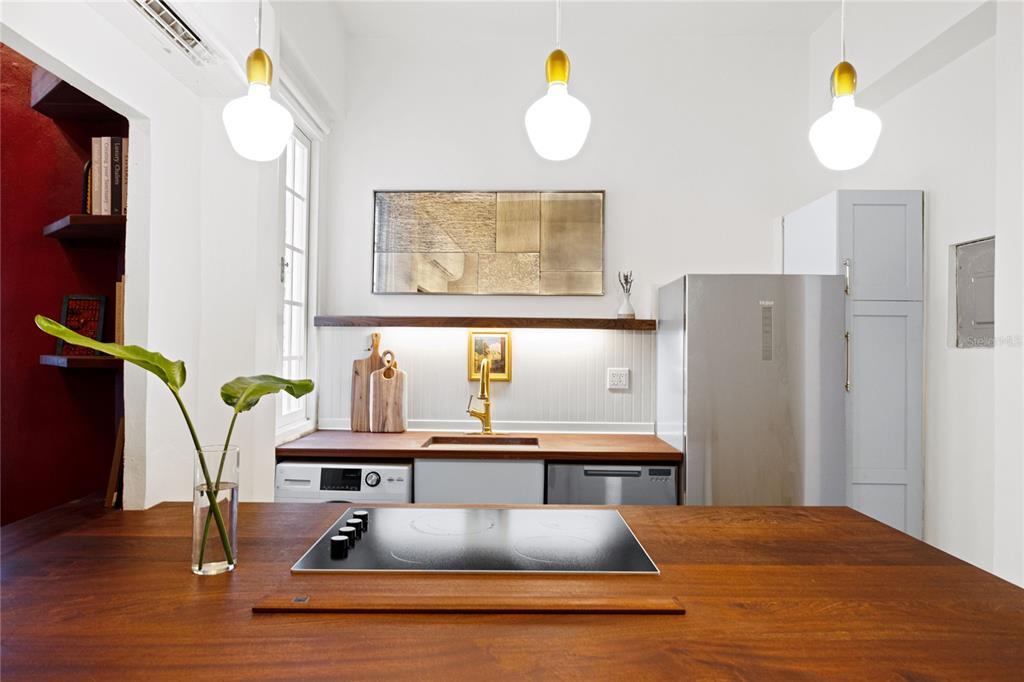 A kitchen features a wooden island with a cooktop, white cabinets, and gold fixtures — 360-362 FORTALEZA UNIT 7, SAN JUAN, PR