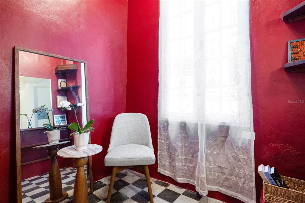 A small room with red walls, a checkered floor, a mirror, and a chair — 360-362 FORTALEZA UNIT 7, SAN JUAN, PR