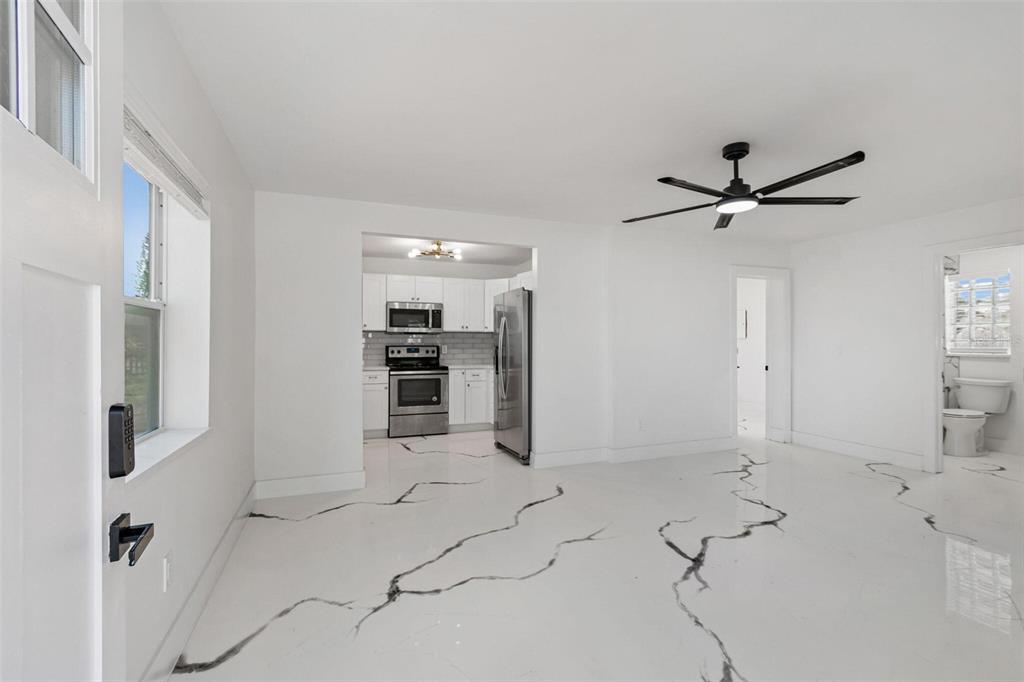 A bright room with white walls and white flooring featuring prominent black marble-like veining — 4125 GROVE, ST PETERSBURG, FL