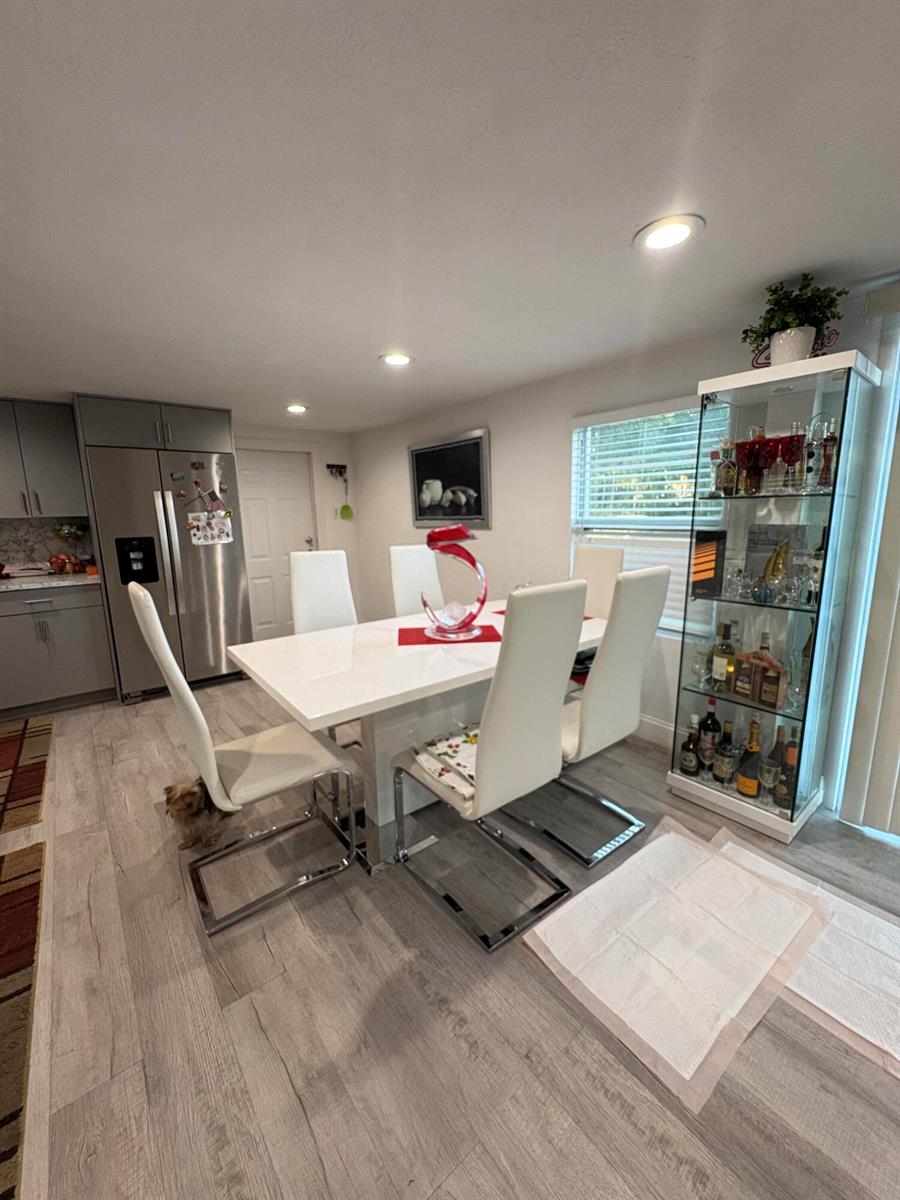 A dining room features a white table, six modern chairs, and a glass display cabinet — 855 N Datil Street, Clewiston FL 33440, CLEWISTON, FL