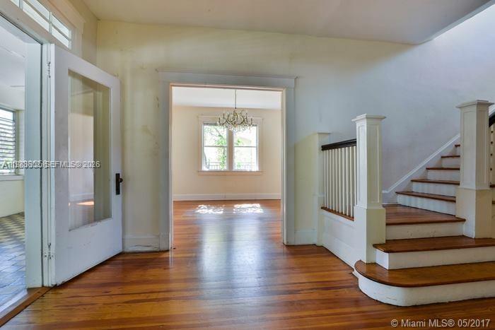 An interior view shows a wooden staircase, hardwood floors, and a doorway leading to another room — 2000 S Miami Ave, Miami FL 33129, MIAMI, FL