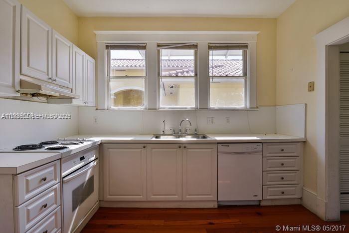 A kitchen features white cabinets, a stainless steel stove, a dishwasher, and a windowed sink — 2000 S Miami Ave, Miami FL 33129, MIAMI, FL