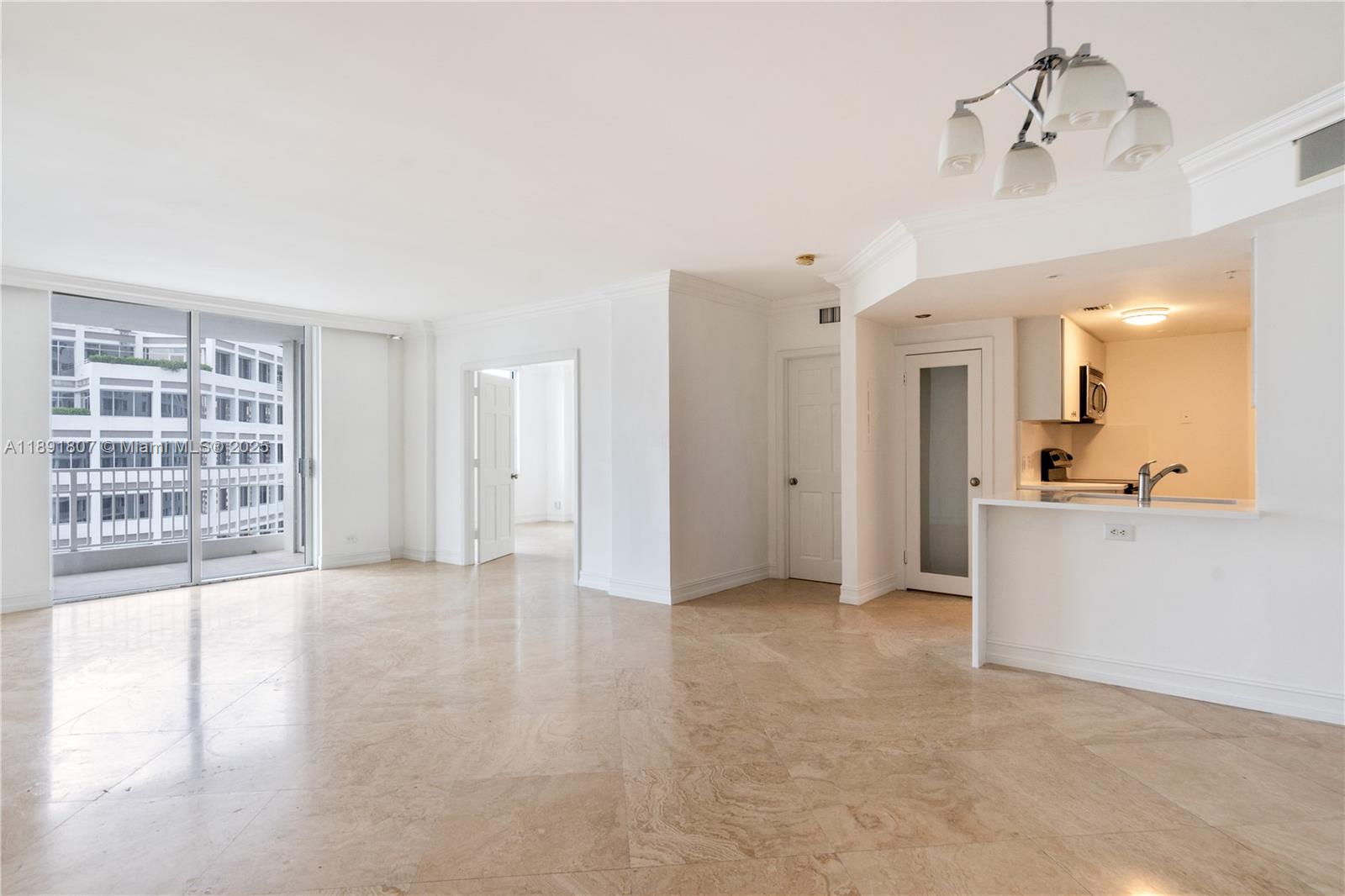 An open-plan living area features beige tile floors, white walls, and an adjacent kitchen — 701 Brickell Key Blvd # 1411, Miami FL 33131, MIAMI, FL