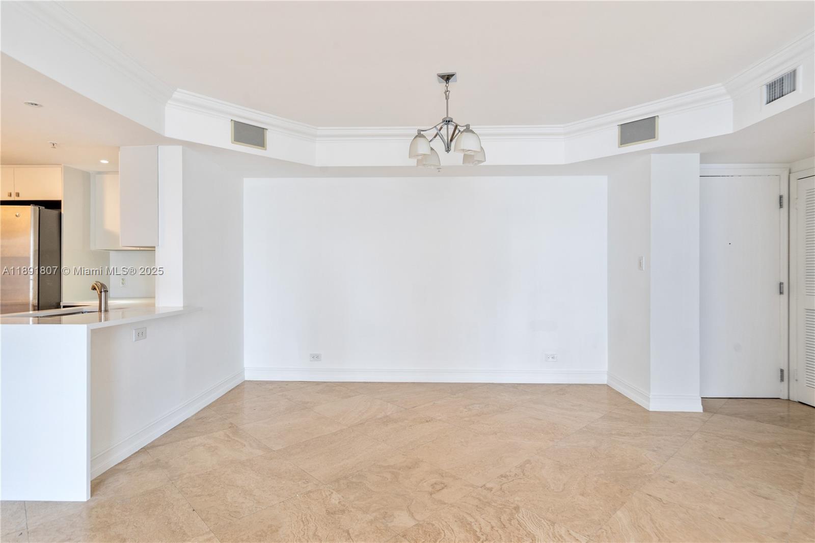 This dining area features white walls, a chandelier, and light-colored tile flooring — 701 Brickell Key Blvd # 1411, Miami FL 33131, MIAMI, FL