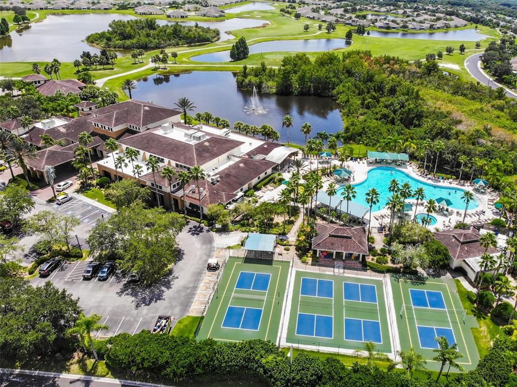 An aerial view shows a clubhouse with a swimming pool and three pickleball courts — 1811 BEDFORD LANE UNIT 164, SUN CITY CENTER, FL