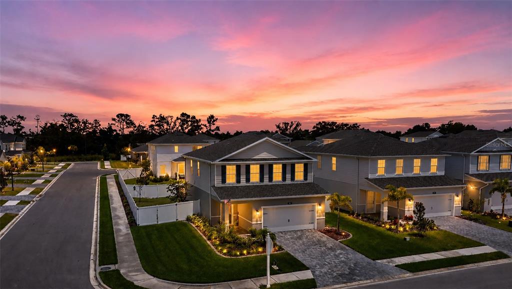 An exterior view of a two-story suburban house at sunset with a paved driveway — 4507 ARDEN WAY, BRADENTON, FL