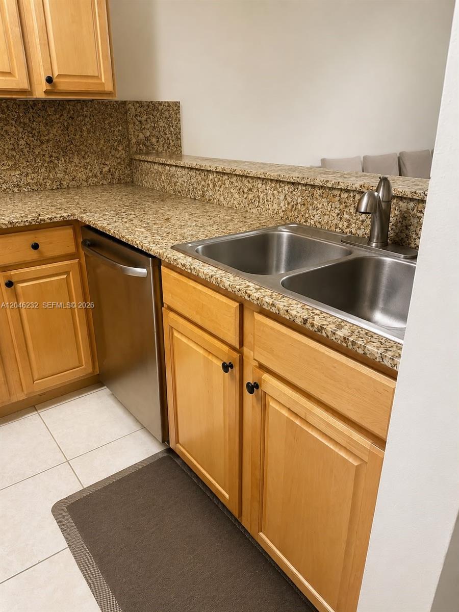 A kitchen features light wood cabinets, granite countertops, a stainless steel dishwasher, and a sink — 7954 NW 41st Ct, Sunrise FL 33351, SUNRISE, FL