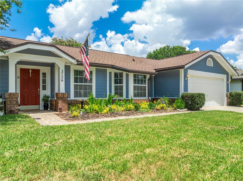 A single-story house with blue siding, a red front door, and an attached garage — 3726 SARASOTA COURT, ORLANDO, FL