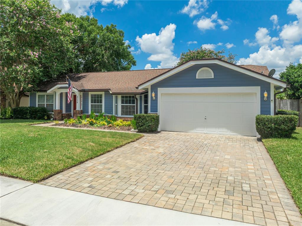 A blue single-story house features a paved driveway, a two-car garage, and a front lawn — 3726 SARASOTA COURT, ORLANDO, FL