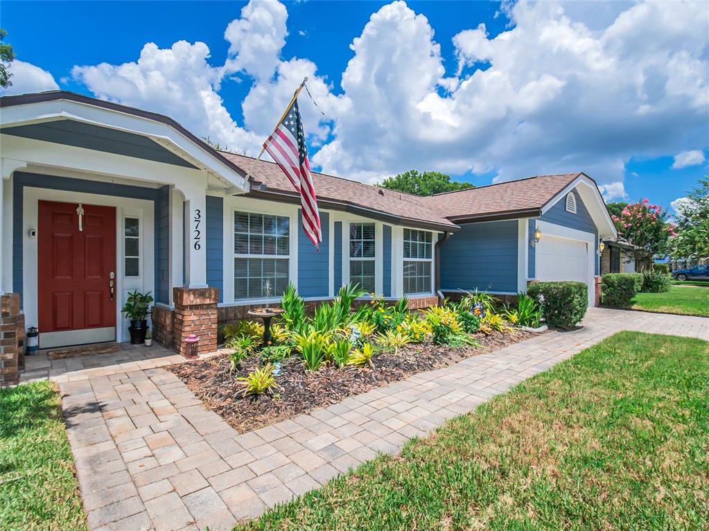 A single-story house with blue siding, a red front door, and a brick-paved walkway — 3726 SARASOTA COURT, ORLANDO, FL