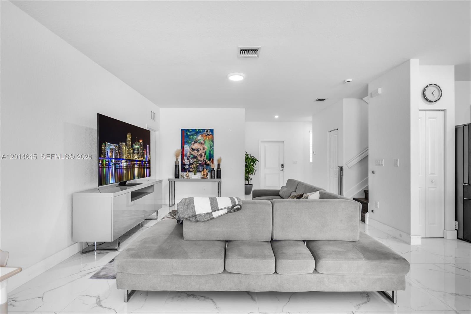 A modern living room features a large gray sectional sofa, white tile floors, and a television — 13629 SW 186th Ln, Miami FL 33177, MIAMI, FL