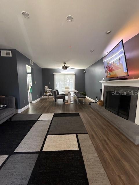 A living room features dark gray walls, wood-look flooring, a fireplace, and a dining area — 9101 MONTEVELLO DRIVE, ORLANDO, FL