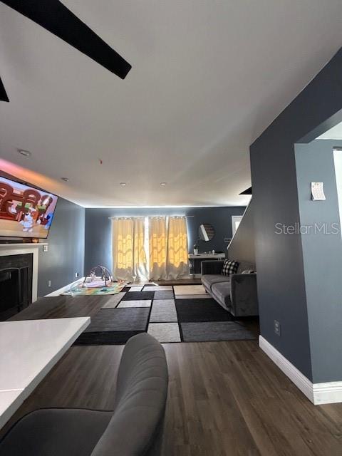 A living room features dark gray walls, wood-look flooring, a large area rug, and a fireplace — 9101 MONTEVELLO DRIVE, ORLANDO, FL