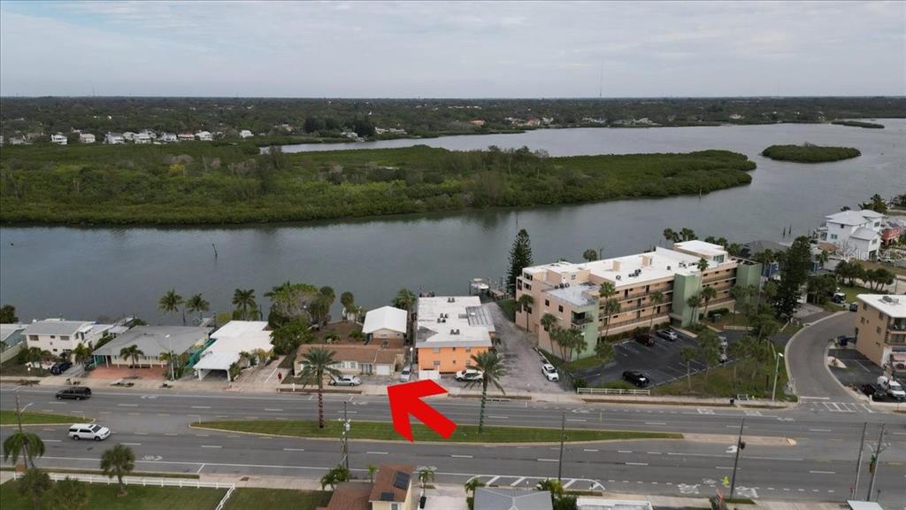 An aerial view shows a waterfront property with a red arrow pointing to the house — 18207 GULF BOULEVARD, REDINGTON SHORES, FL