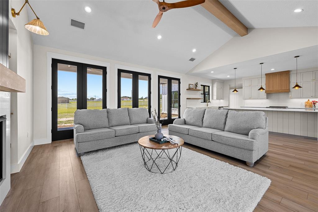 A living room with two gray sofas, a coffee table, and an open-concept kitchen — 389 SW MOSSY OAK WAY, LAKE CITY, FL