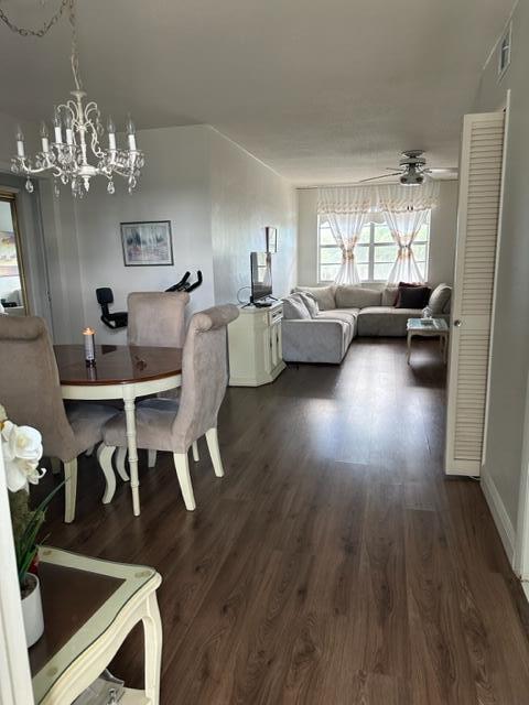An open-concept living and dining area features wood-look flooring, a chandelier, and a sectional sofa — 1380 NW 43 Terrace # 306, Lauderhill FL 33313, LAUDERHILL, FL