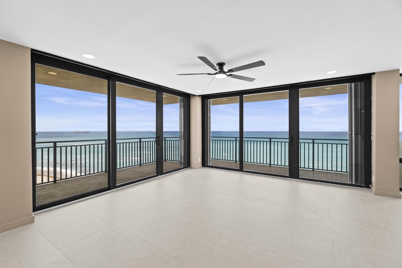 An empty room features large sliding glass doors opening to a balcony with ocean views — 5460 N Ocean Drive # 6a, Riviera Beach FL 33404, RIVIERA BEACH, FL