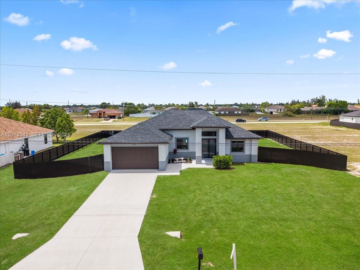 An aerial view shows a single-story house with a gray roof and a concrete driveway — 1925 NW 15TH TER, Cape Coral FL 33993, CAPE CORAL, FL