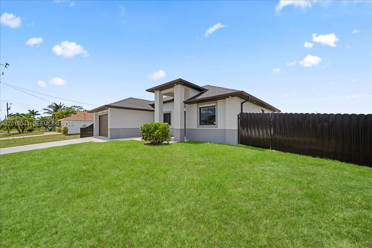 A single-story house with a gray exterior, a dark roof, and a black privacy fence — 1925 NW 15TH TER, Cape Coral FL 33993, CAPE CORAL, FL