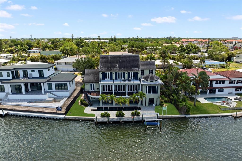An aerial view shows a multi-story waterfront house with a pool and private boat dock — 6438 HOLLYWOOD BOULEVARD, SARASOTA, FL