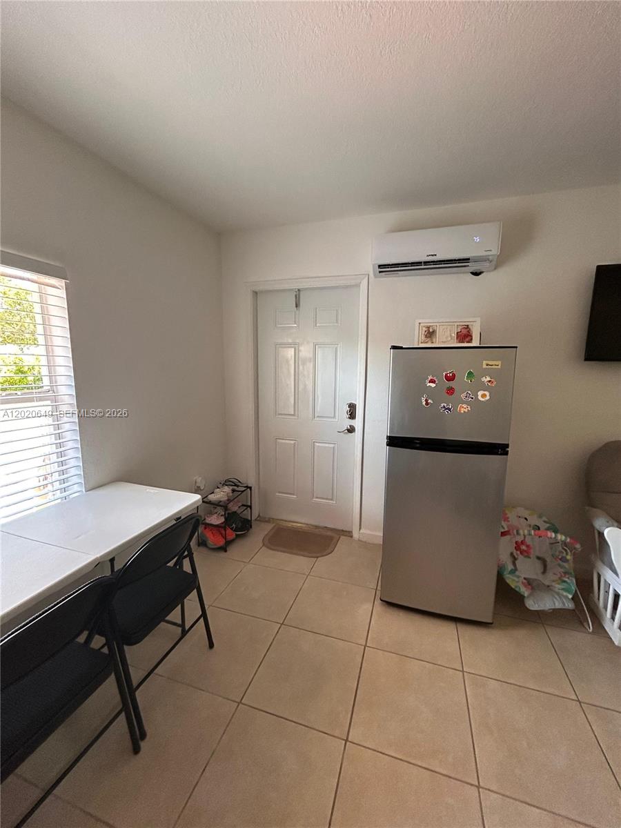 A small room features tile flooring, a white door, a refrigerator, and a dining table — 12805 SW 116th Ct # 1, Miami FL 33176, MIAMI, FL