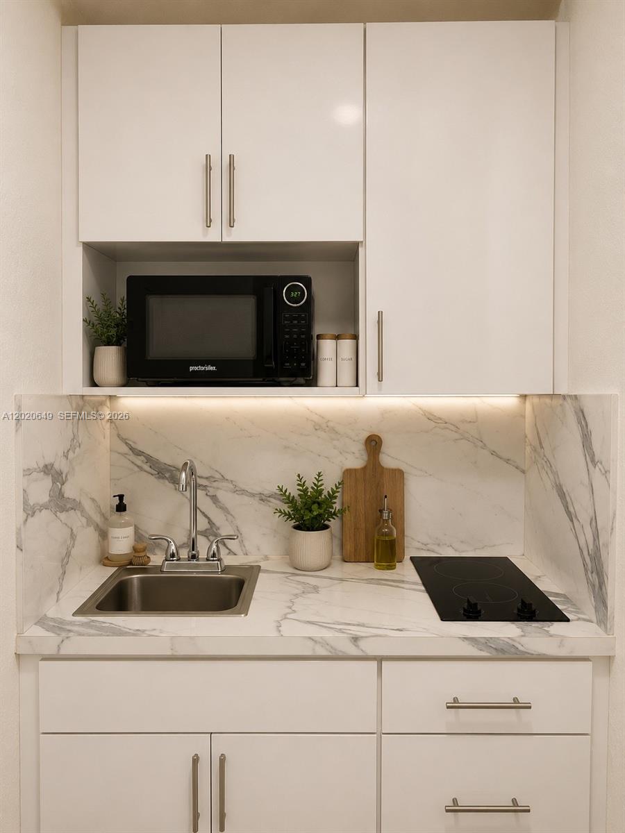 A small kitchen area features white cabinets, a marble-patterned countertop, a sink, and a microwave — 12805 SW 116th Ct # 1, Miami FL 33176, MIAMI, FL